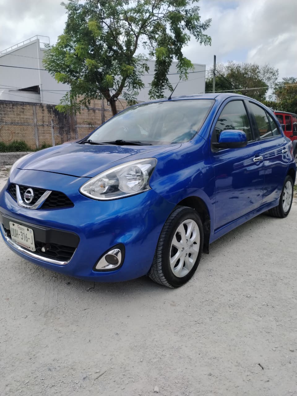 Hatchback Nissan azul en lote de seminuevos
